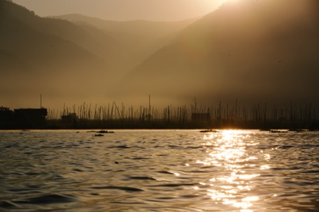 the sun rises behind the mountains